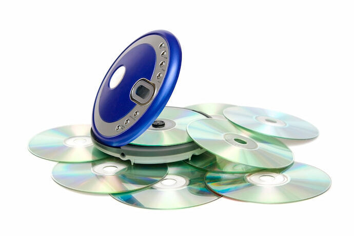 CD player portátil em fundo branco com CD's espalhados