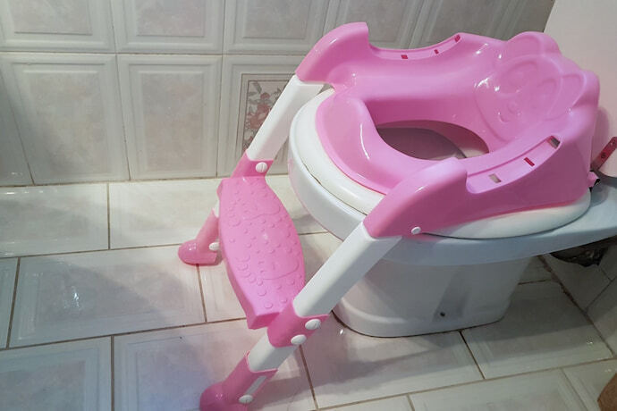 redutor de assento rosa no banheiro