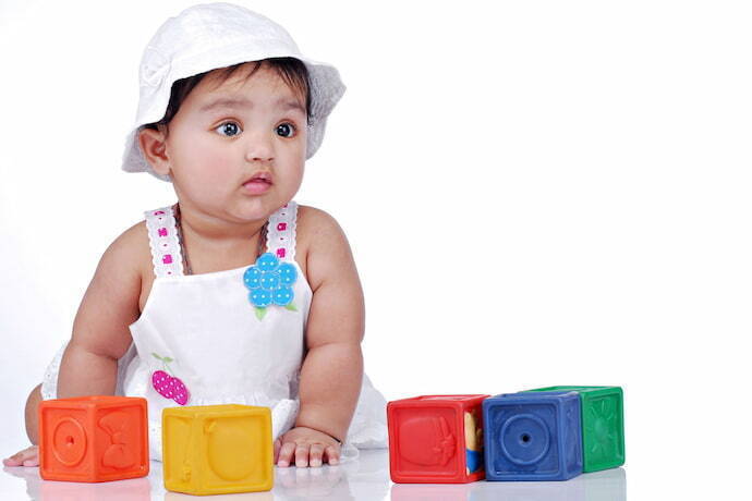 Bebê de 6 meses com vários blocos de brinquedo.