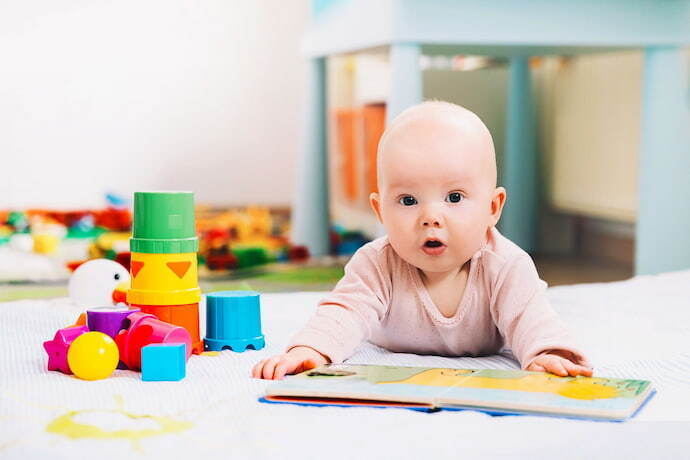 Bebê com livro e blocos de brinquedo. 