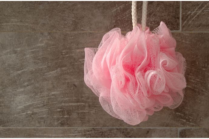 Esponja de banho de nylon rosa perdurada por corda.