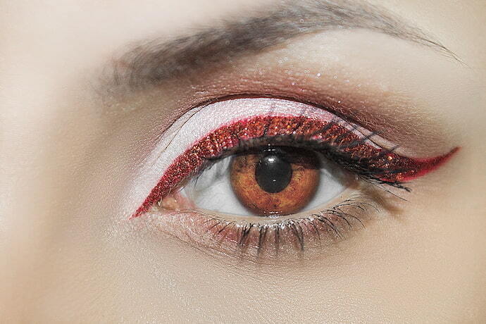 Close-up em olho maquiado com delineador vermelho brilhante