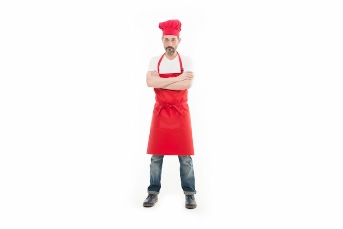 Homem com avental de cozinha vermelho e touca combinando.