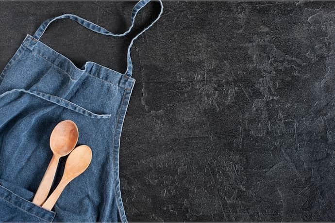 Avental de cozinha jeans com colheres de pau.