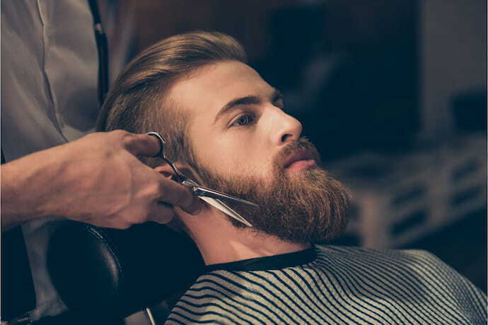 Homem com barba grande fazendo a barba. 