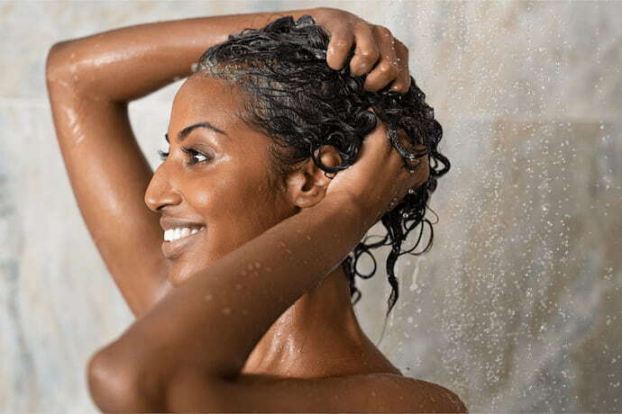 Mulher lavando o cabelo no chuveiro