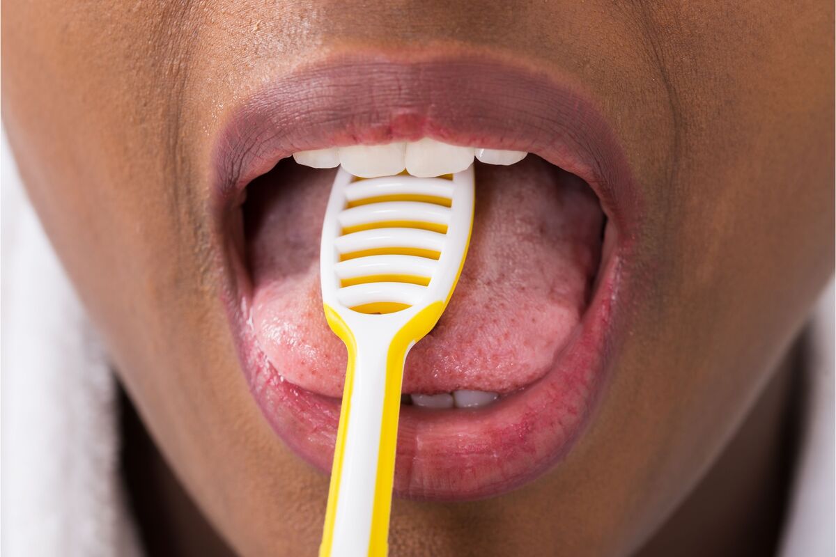 limpando a lingua com limpador amarelo