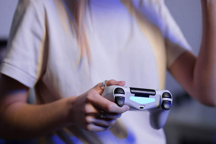 Mão feminina segurando controle de videogame
