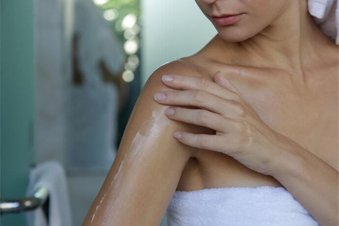 Passando oleo corporal na pele