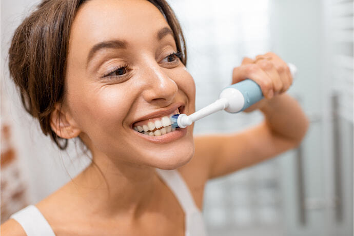 pessoa usando escova de dente elétrica