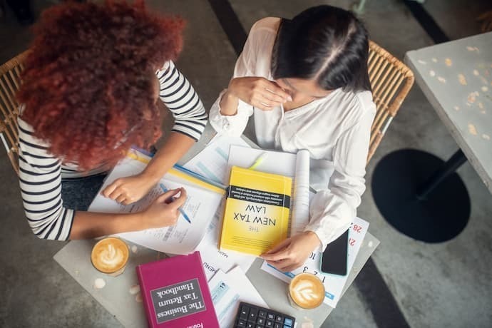 Mulheres estudando com livros de negócios e empreendedorismo