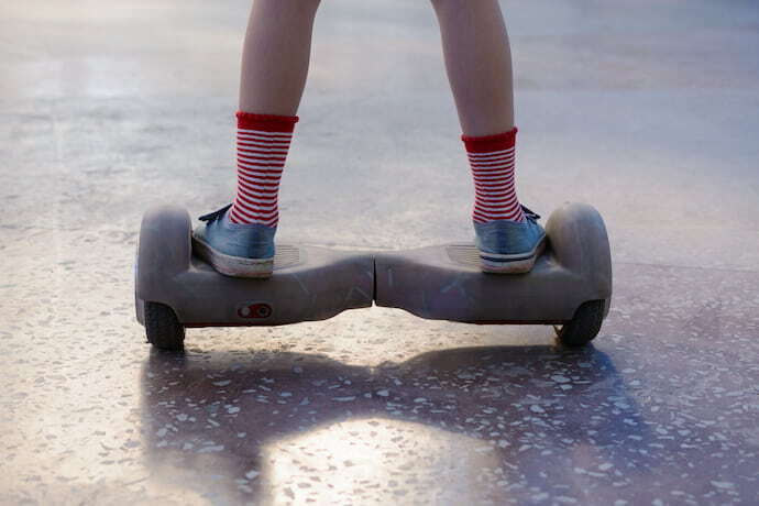 Menina andando em hoverboard cinza.
