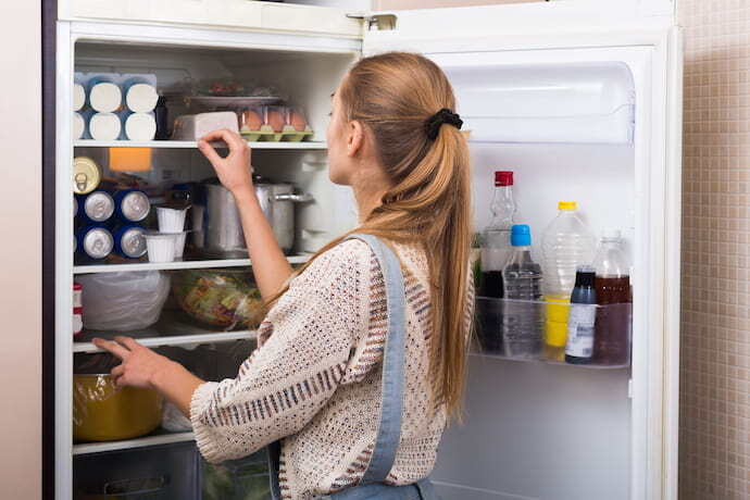 Mulher olhando para dentro da geladeira