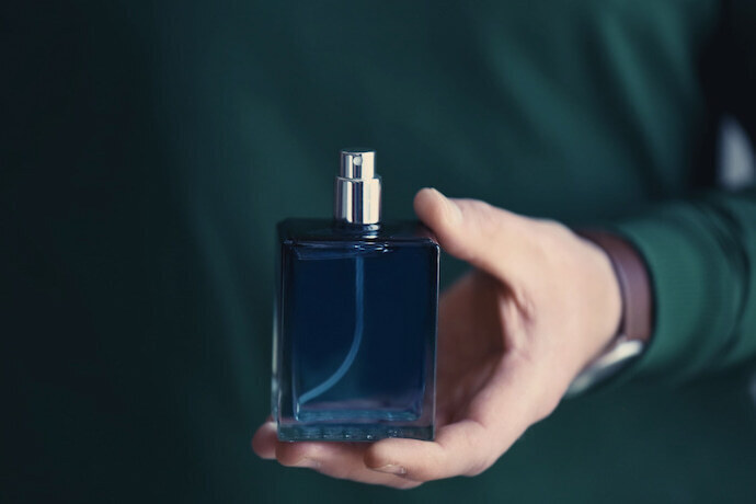 Homem segurando perfume masculino.