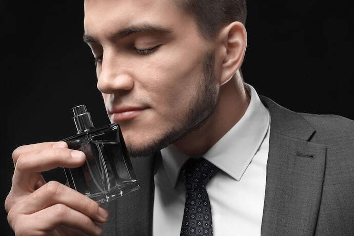 Homem cheirando perfume masculino. 