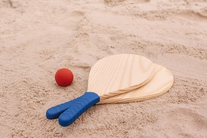 Duas raquetes de Beach Tennis de madeira com bolinha vermelha.