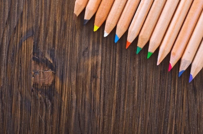 Lápis coloridos em fundo de madeira