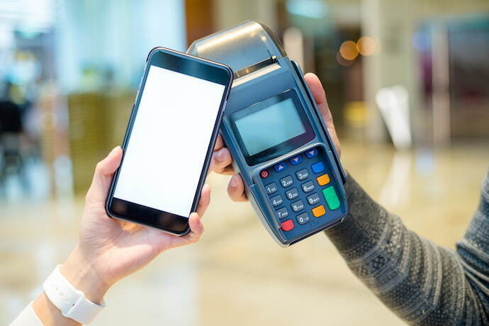Pessoa com celular com NFC fazendo pagamento