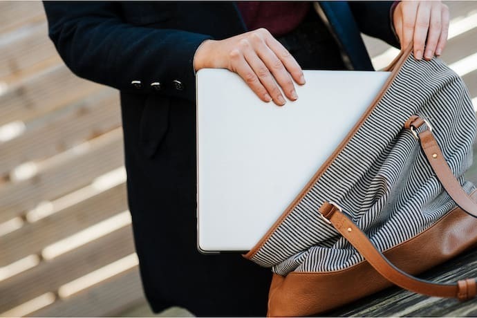 Pessoa colocando notebook com SSD em bolsa.