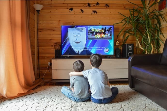 Crianças assistindo desenho em TV Philco.