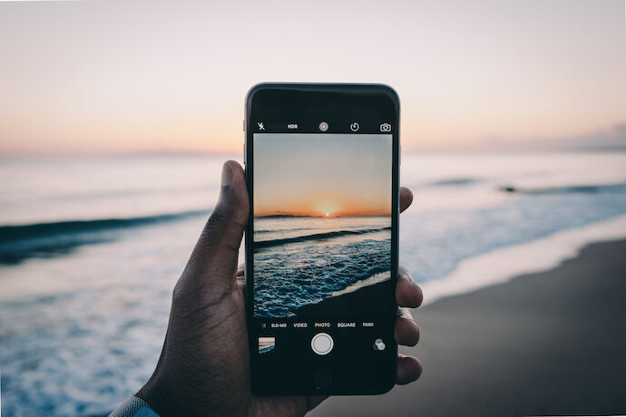 Pessoa com Iphone tirando foto do mar