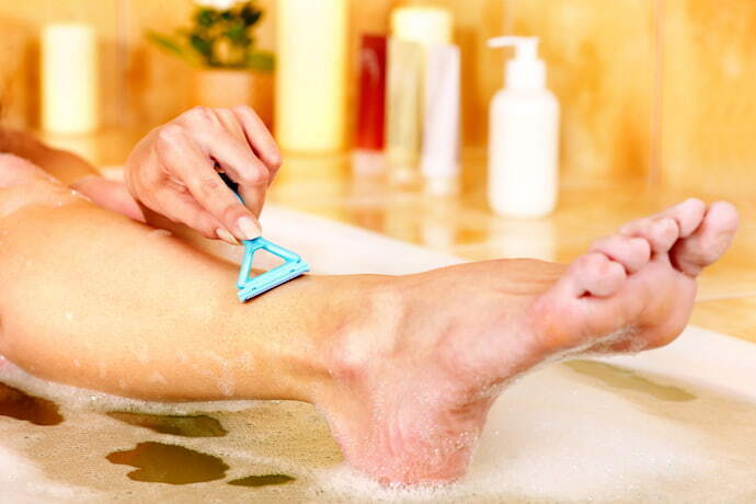 Pessoa depilando a perna