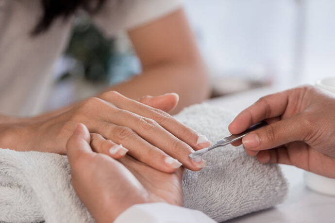 Manicure aplicando amolecedor de cutícula