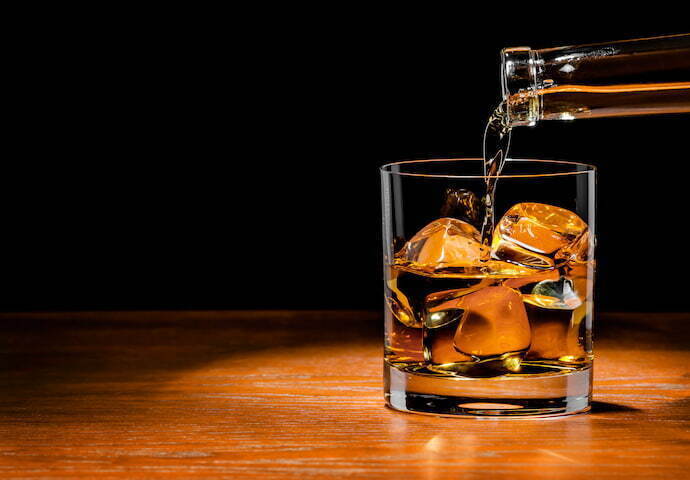 Colocando whisky no copo