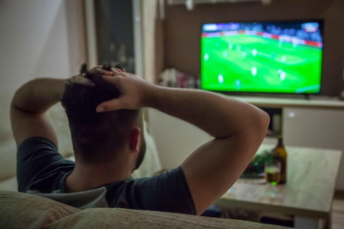 Homem vendo futebol em TV de 40 polegadas.