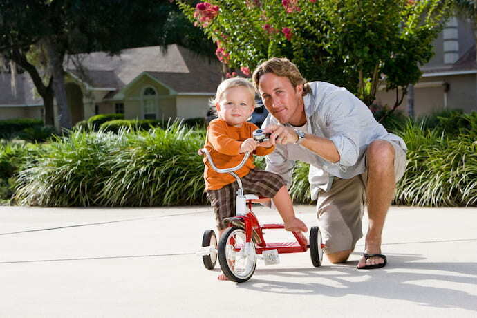 Criança brincando com triciclo infantil
