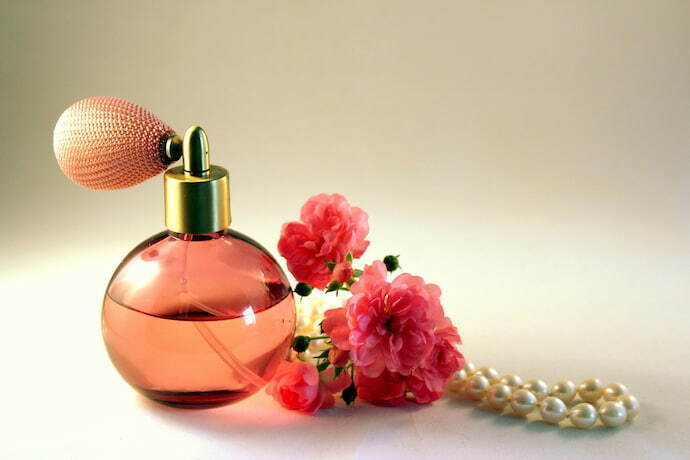 Perfume ao lado de flores