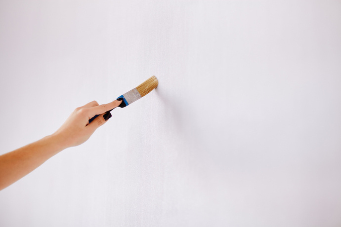 Pessoa pintando a parede com tinta antimofo