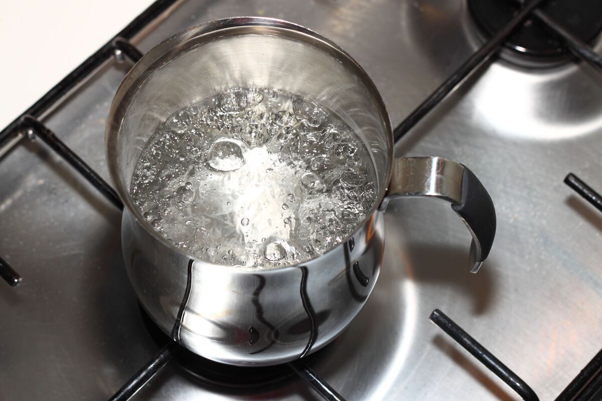 Água fervendo em caneca no fogão