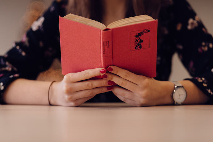 Mulher lendo livro de capa vermelha