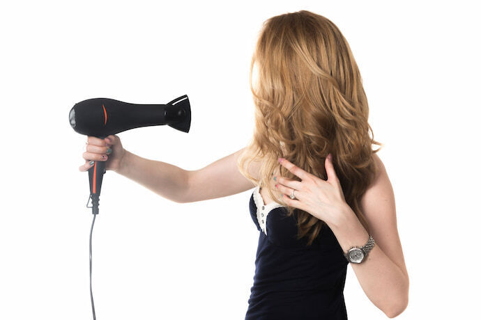 Mulher secando cabelo com secador profissional para salão