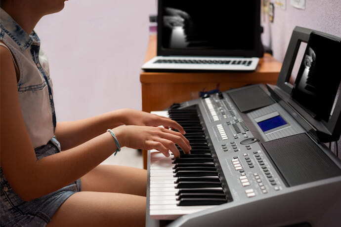 Menina tocando teclado musical