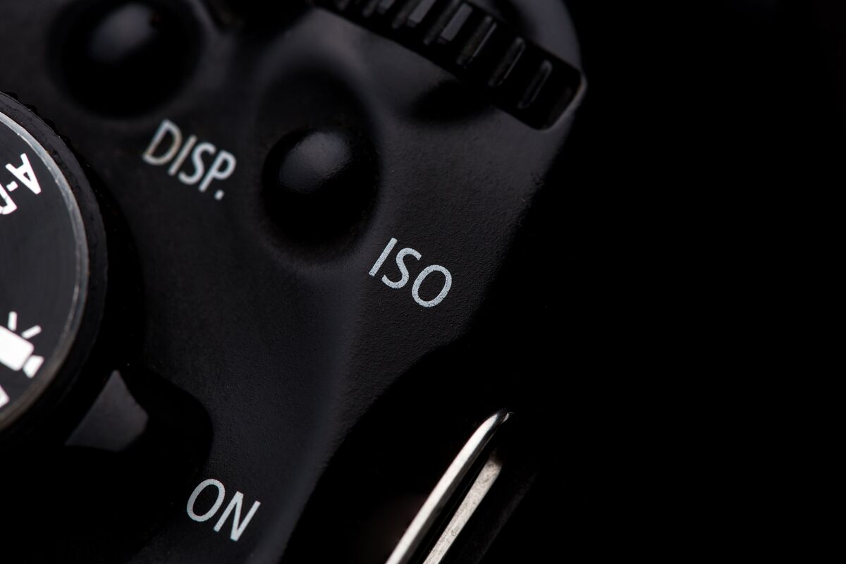 Foto aproximada dos botões de uma câmera, com foco no botão ISO