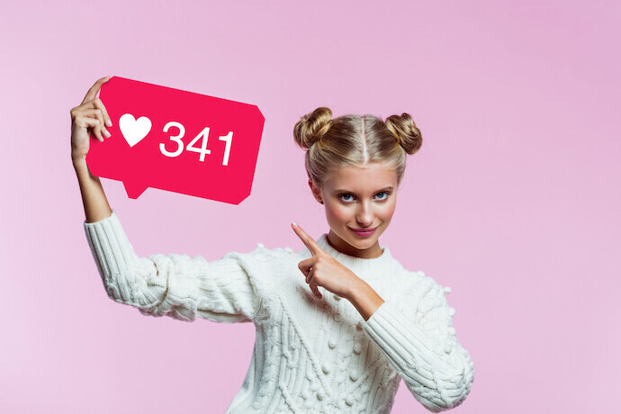 influenciadora digital segurando "gostei" do instagram