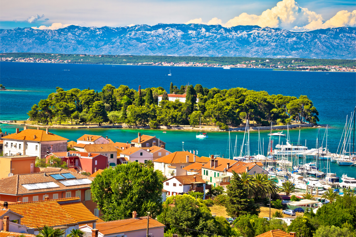 Paisagem de várias casas próximo ao mar e barcos ancorados 