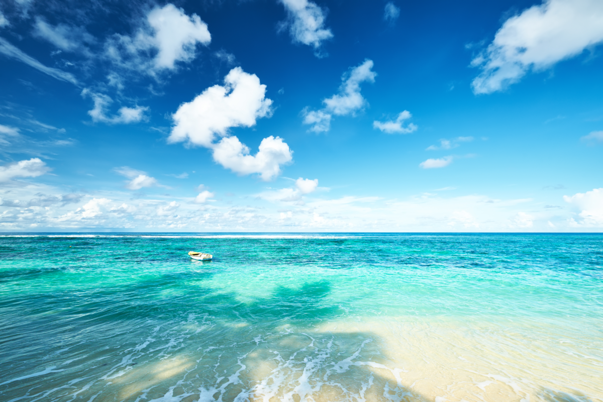 Praia com a água cristalina em Seychelles e um barco