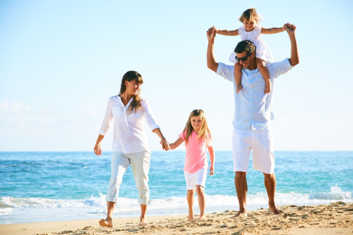 Uma família feliz caminhando na praia
