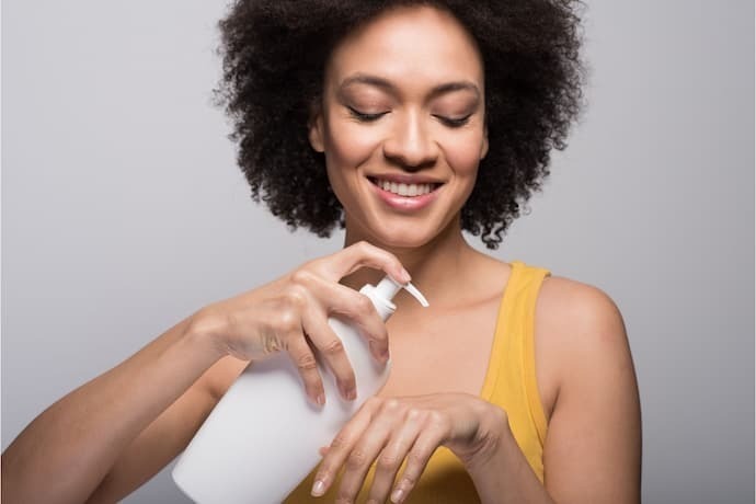 Mulher colocando sabonete liquido nas costas da mão