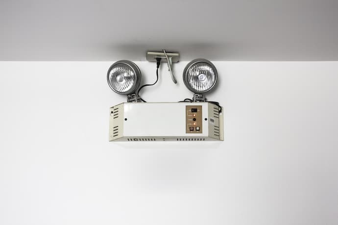 A imagem destaca uma luz de emergência com duas lampadas