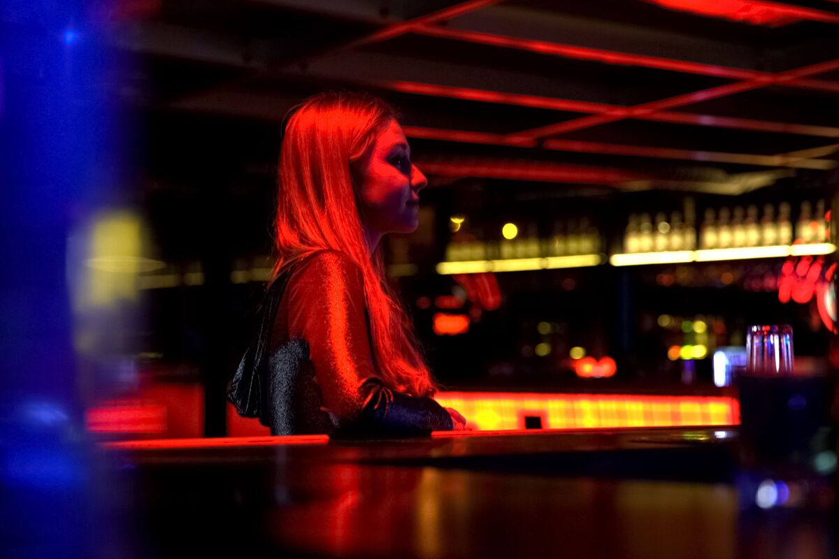 Mulher sentada em bar de balada à noite
