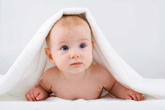 Bebê em volta de sua toalha branca