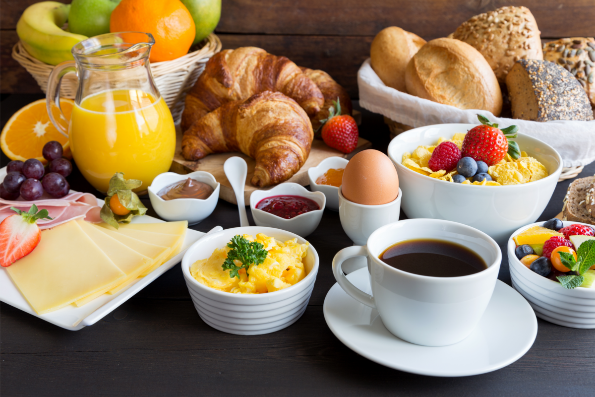 mesa de café da manhã com várias bebidas e comidas