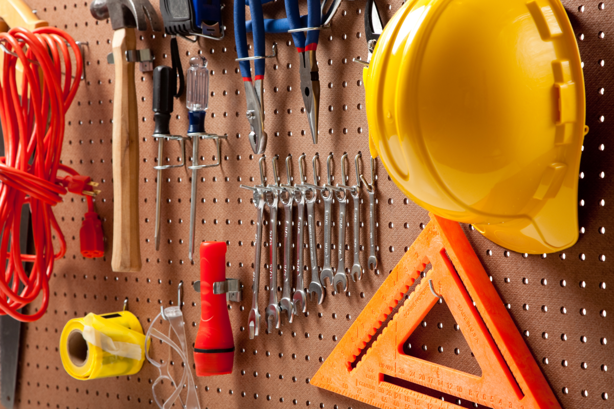 Pegboard bege organizando ferramentas de construção.