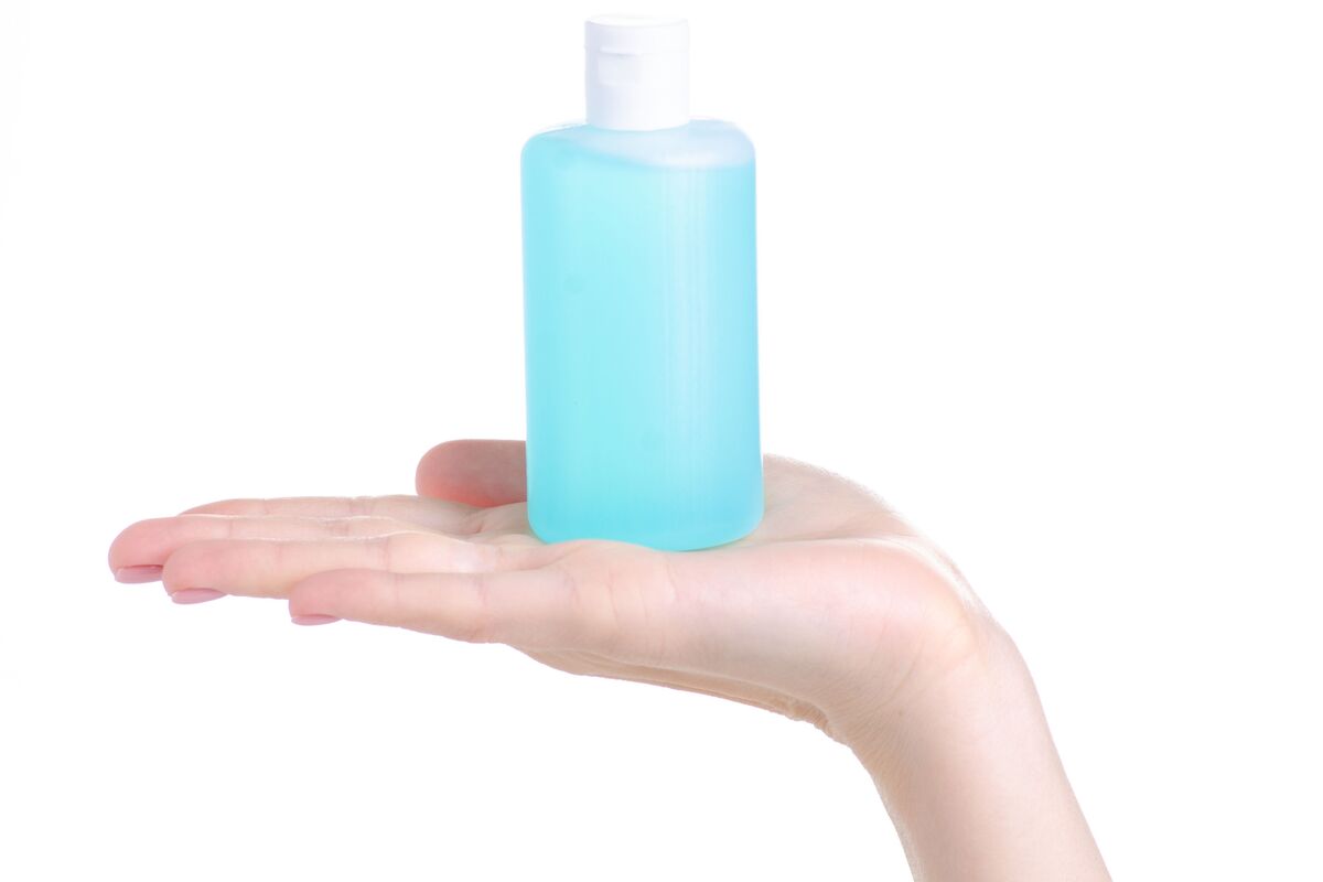 Pessoa segurando frasco com líquido azul (acetona)