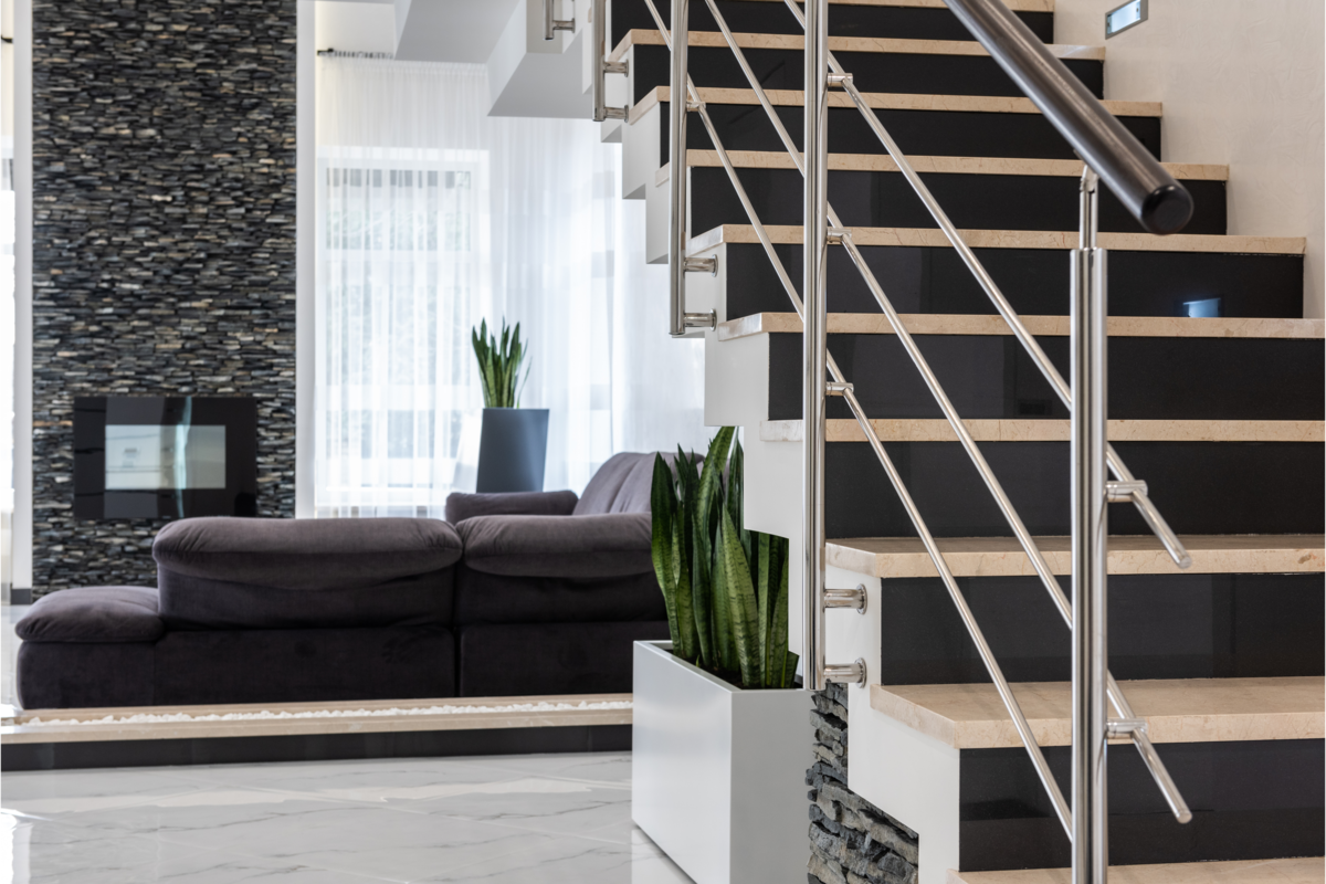 Casa moderna com escada e sofá aconchegante decorado com plantas.