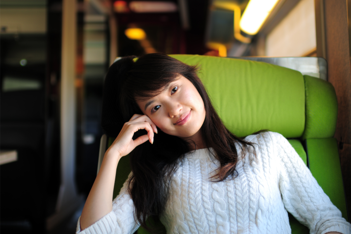 Uma mulher feliz em uma cadeira de ônibus de viagem